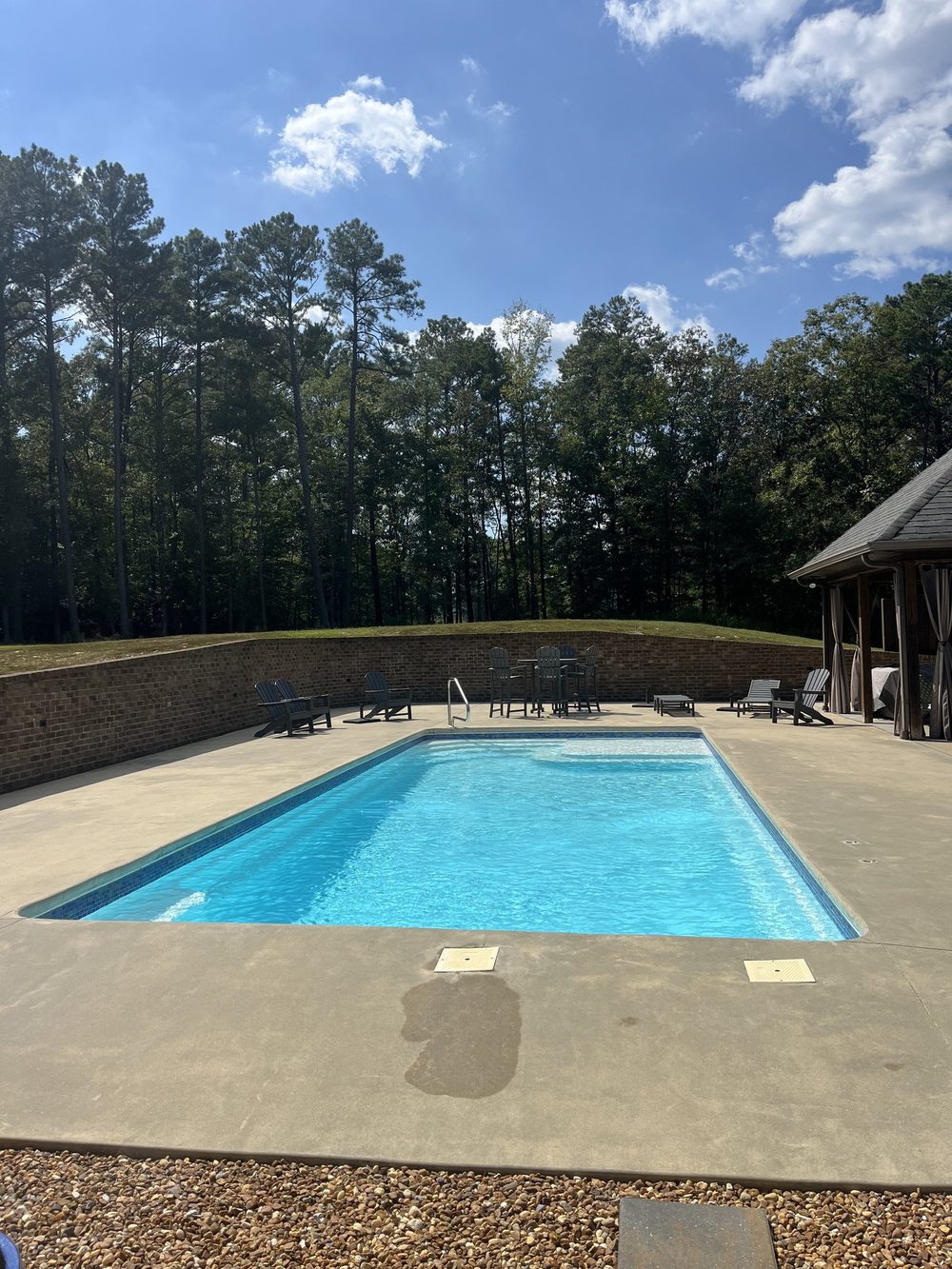 Clear pool with a brick patio and poolside pavilion