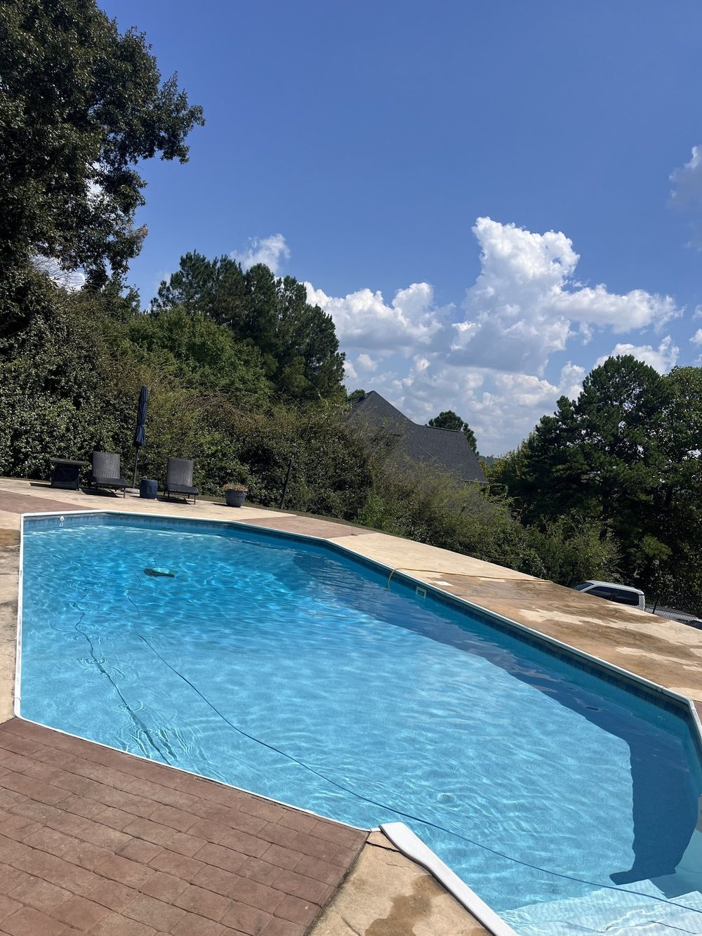 Clear backyard pool with a lounge deck on a sunny day