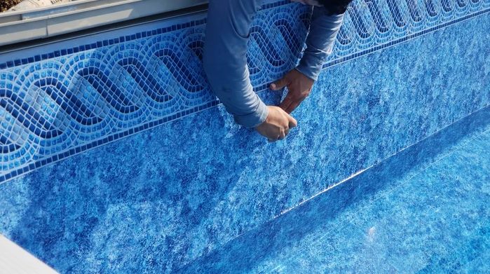 Technician installing a new vinyl pool liner